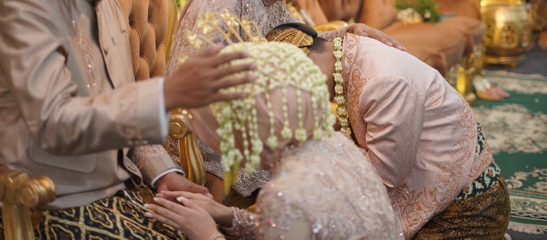 The Bride and Groom Kneel on Her Parent's Lap during The Wedding Ceremony in a Traditional Wedding Ceremony in Indonesia photo
