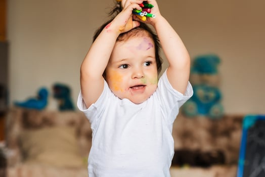 cute little boy holding colored pencils and markers photo