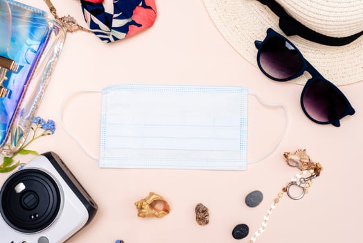 summer travel accessories. women's set of adult toys, camera, hat, glasses, protective mask and gloves on a light background. photo