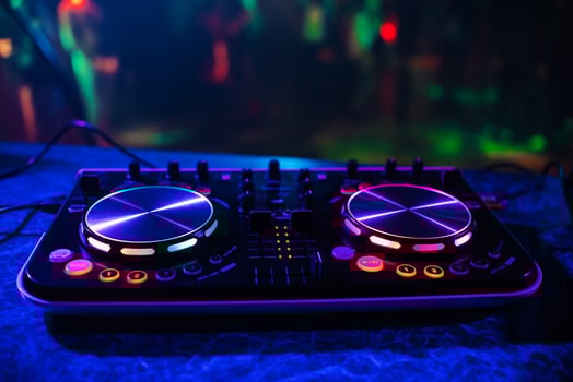 DJ console for mixing music with blurry people dancing at a nightclub party photo
