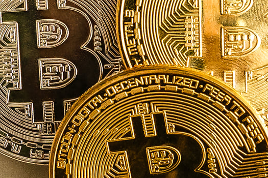 Bitcoin upright on a laptop keyboard photo