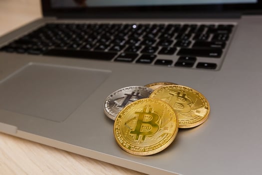 Bitcoin upright on a laptop keyboard photo