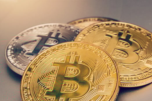 Bitcoin upright on a laptop keyboard photo