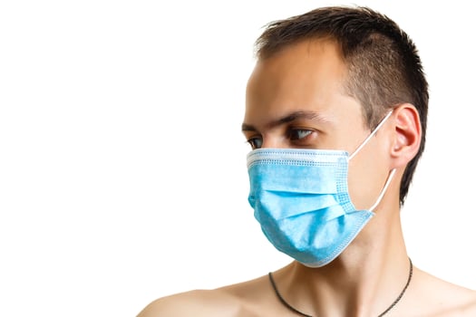Close up portrait of young doctor in mask isolated on white background photo