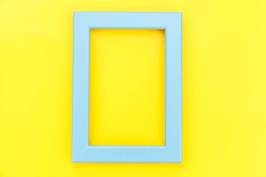 Simply design with empty blue frame isolated on yellow colourful trendy background. Top view, flat lay, copy space, mock up. Minimal concept. photo