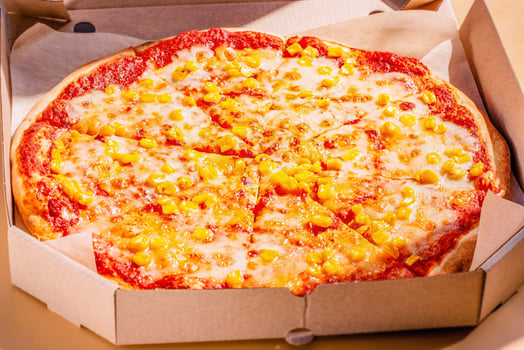 Vegan pizza with corn and tomato sauce. Food delivery. Pizza in a package. photo