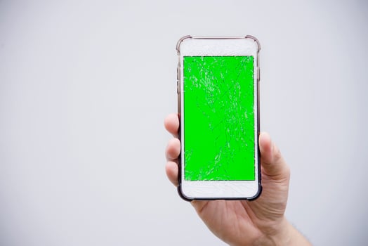 Hand holding mobile phone with broken cracked screen display need to be fixed, mobile repair shop concept photo