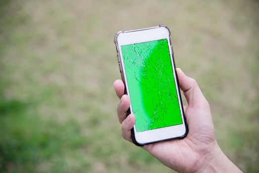 Hand holding mobile phone with broken cracked screen display need to be fixed, mobile repair shop concept photo