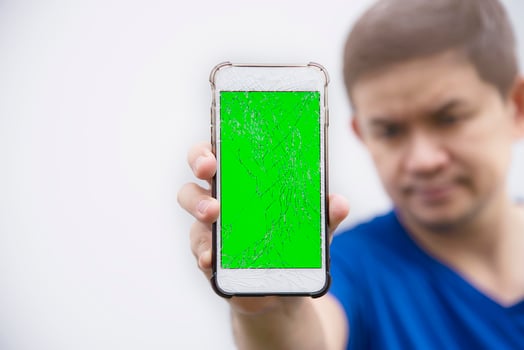 Man seriously looking at mobile phone with broken cracked screen display need to be fixed, mobile repair shop concept photo