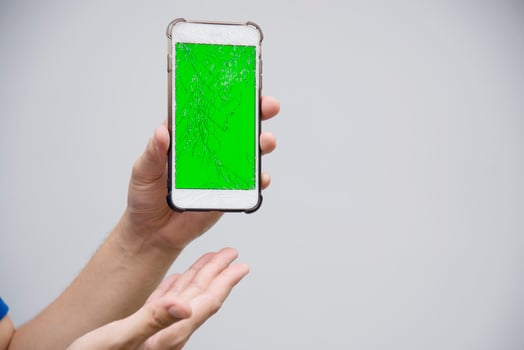 Hand holding mobile phone with broken cracked screen display need to be fixed, mobile repair shop concept photo