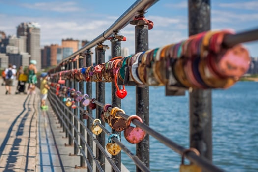A heart-shaped door lock, a symbol of love and fidelity with a lake in the background, hangs on the fence of the bridge. The heart-shaped castle symbolizes loyalty and love photo