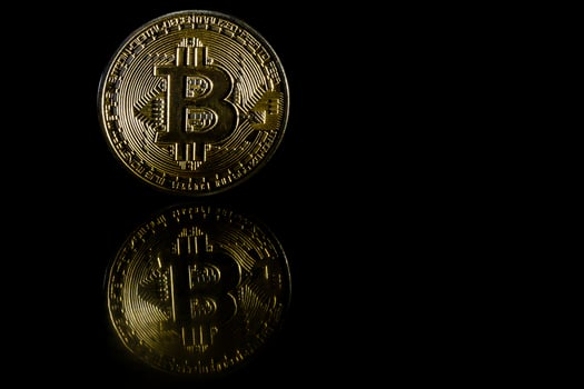 Golden bitcoin on black background with copy space cryptocurrency mining concept photo