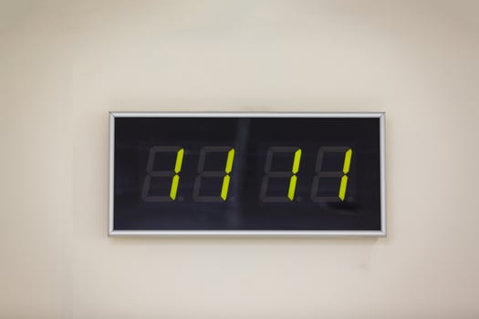 Black digital clock on a white background showing time eleven hours eleven minutes photo