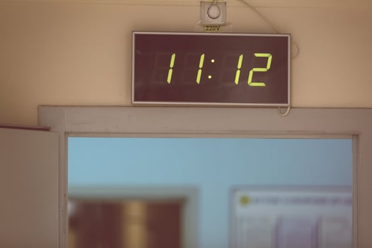 Black digital clock on a white background showing time eleven hours twelve minutes photo