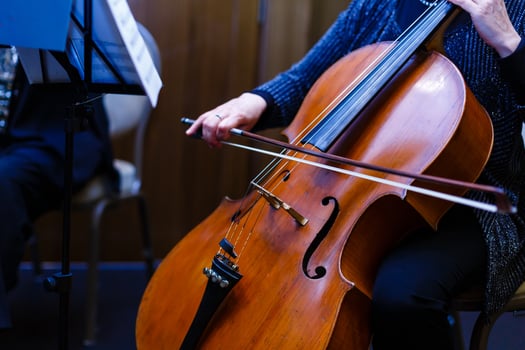 A young girl plays the cello in the dark. Hands on cello photo