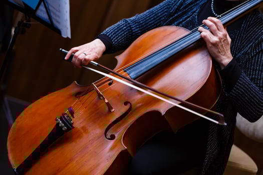 A young girl plays the cello in the dark. Hands on cello photo