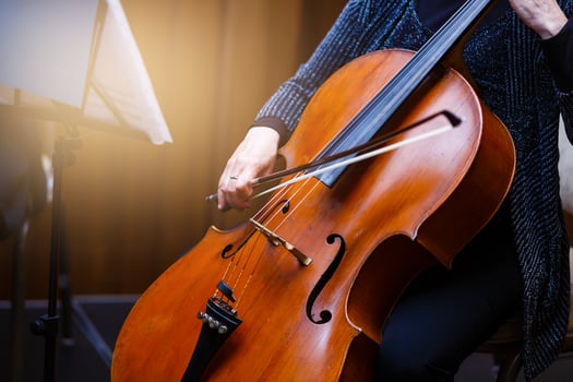 A young girl plays the cello in the dark. Hands on cello photo