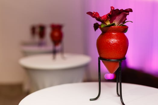 a red flowerpot with flowers on a stand photo