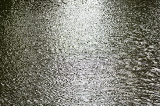 Raindrop impact on rippling water surface photo