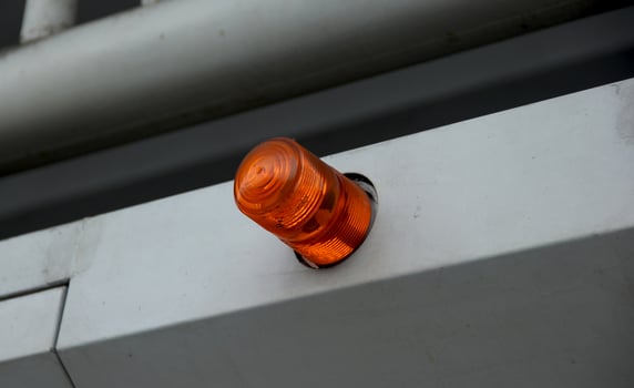 Orange fire alarm on white walls in off mode. Security wall alarm technology alert. photo