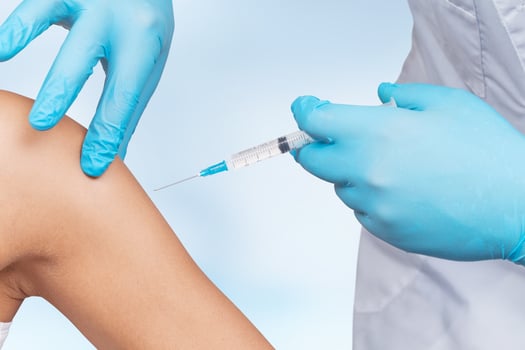 Doctor gives a syringe with vaccine to patient at clinic. photo