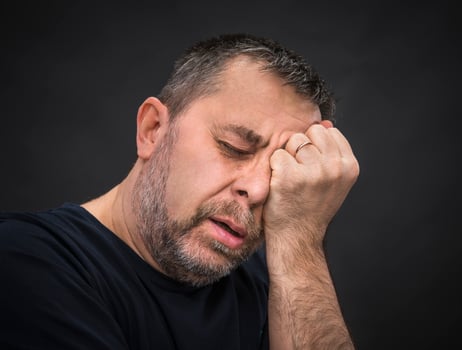 Headache. Man with face closed by hand photo