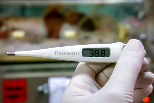 Closeup Medical thermometer in hands of doctor on blurry background.. photo