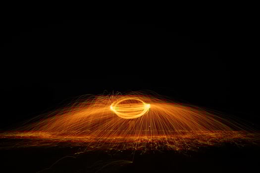 Spinning and burning Steel wool sparkle fire in the circle shape with long speed shutter shoot glowing light line to the ground. photo