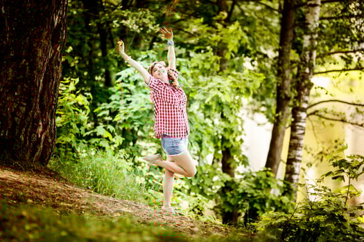 beautiful young girl in a plaid shirt and short denim shorts in pin-up style stays in water of river photo
