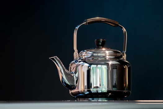 Stainless Water Crow or Vintage Kettle tea pot on electronic stove in modern dark blue background. photo