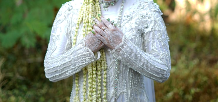 Bride Holding Jasmine and Magnolia Flower Necklace Traditional Wedding Ceremony photo
