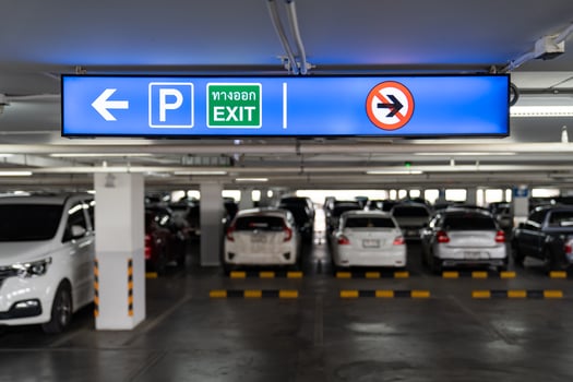 Signage Lightingbox in the indoor carparking, tell driver which way is parking lot or exit. Thai Language in green square on lightinbox means EXIT. photo