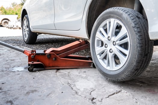 close up to the Fixing of broken tire with white car in Thailand local garage. photo