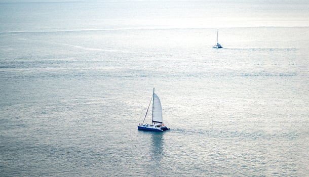minimal Sailboat Yacht is saling on the calm sea, shoot this image from above of the mountain Phrom Thep Cape, Phuket Thailand with Tele lens. photo