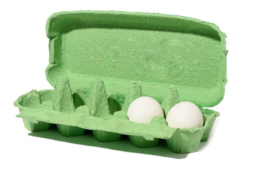 Green cardboard container for fresh chicken eggs on a white isolated background photo