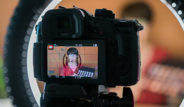 Beauty and cosmetics e-commerce and blogging concept - professional mature female make up artist testing new cosmetics recording video review on cosmetic products at home photo