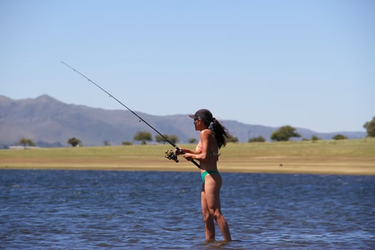 beautiful young woman fishing the mountain lake photo