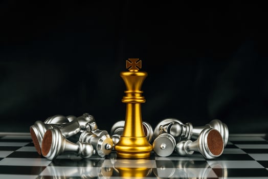 Winner. gold king surrounded with silver chess pieces on chess board game competition with copy space on dark background, chess battle, success, team leader, teamwork and business strategy concept photo