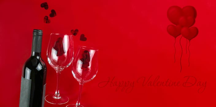 Happy Valentine's Day. Valentine banner. Wine and two glasses on a red background, hearts. Copy space photo