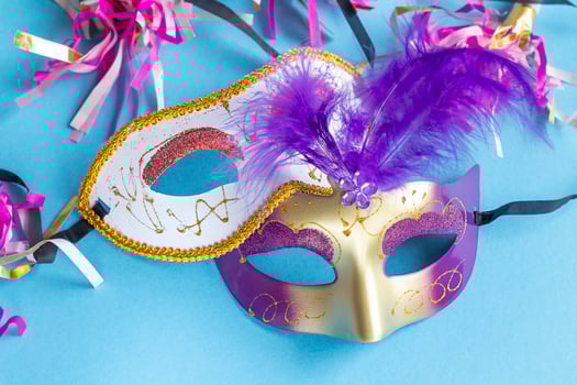 Festive face mask for carnival celebration on blue background. Mardi gras carnival background with carnival masks. photo