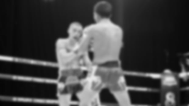Blurred images black and white photo style of Thai boxing or Muay Thai or Kickboxing which local and foriegn boxer are fighting on the ring at indoor stage as martial art sport. Muay Thai Kick boxing