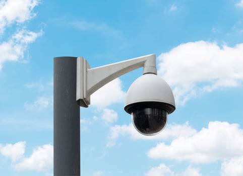 Outdoor white CCTV on pole with blue sky background and copy space photo