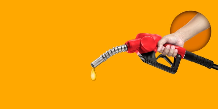 Man holding refueling nozzle on yellow background photo