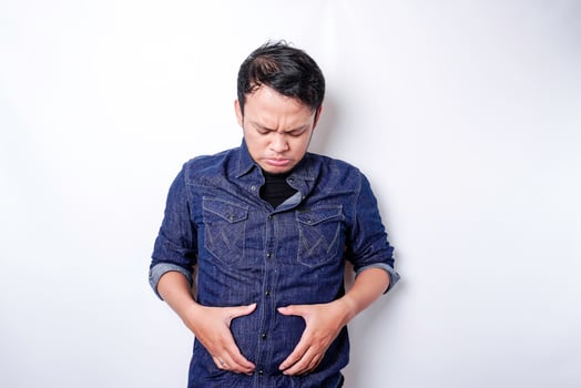 A portrait of insecure Asian fat man is holding the fat on his belly photo