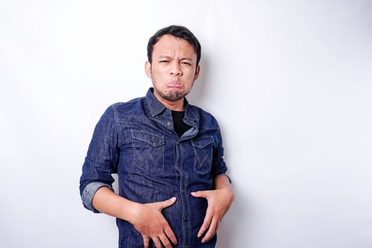 A portrait of insecure Asian fat man is holding the fat on his belly photo