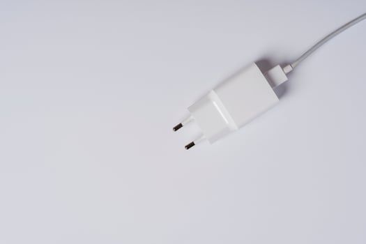White phone charger close-up on a white background, copying space photo