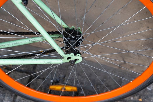 The wheel of a city bike parked against the wall of a cafe in the city, cycling to work photo