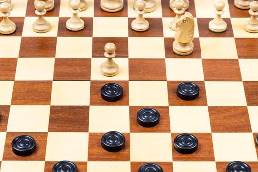 beginning of chess - checkers game on wood board photo
