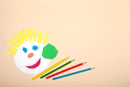 Paper crafts for children. Application of children's creativity. Kindergarten and craft school. On a beige background, a funny face of a man made of colored paper. photo