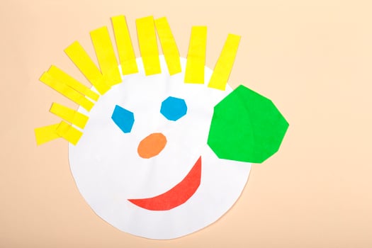 Paper crafts for children. Application of children's creativity. Kindergarten and craft school. On a beige background, a funny face of a man made of colored paper. photo